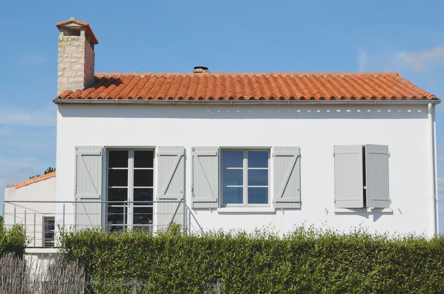 Maison française aux volets gris et toit de tuiles